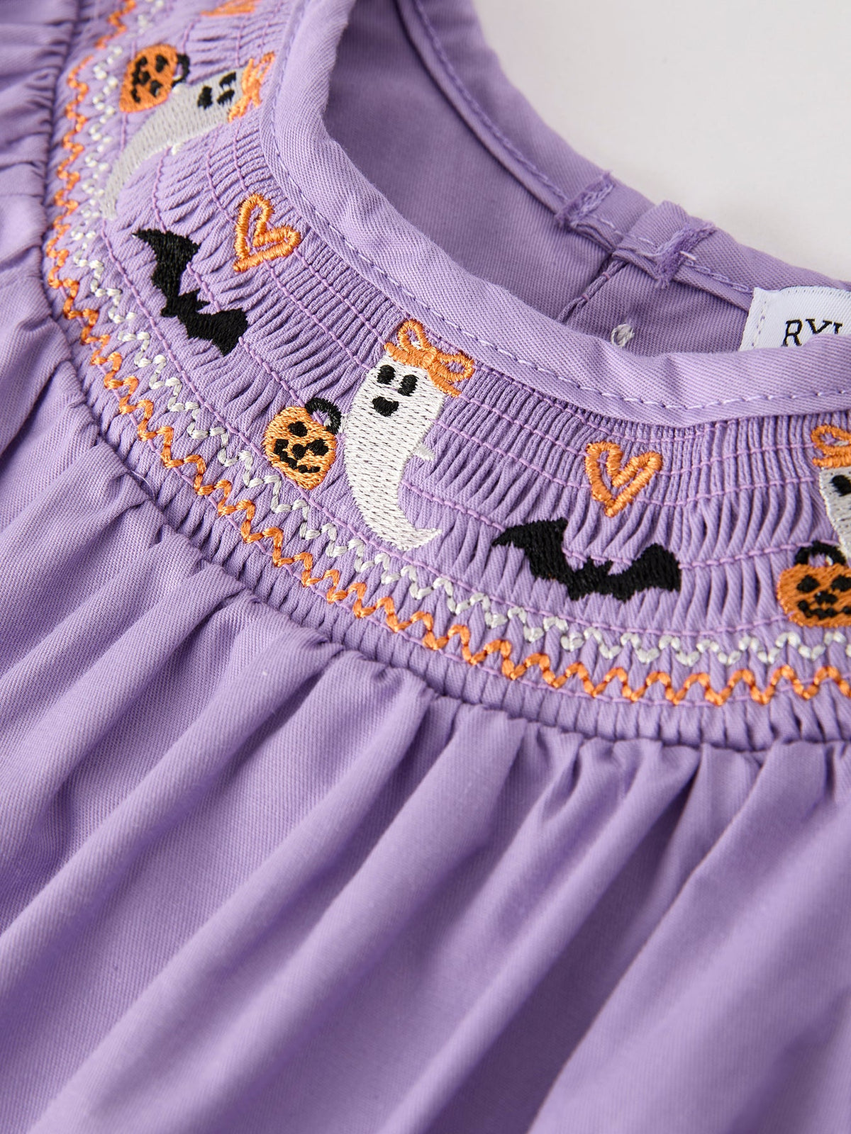 a purple dress with a white ghost and pumpkins on it