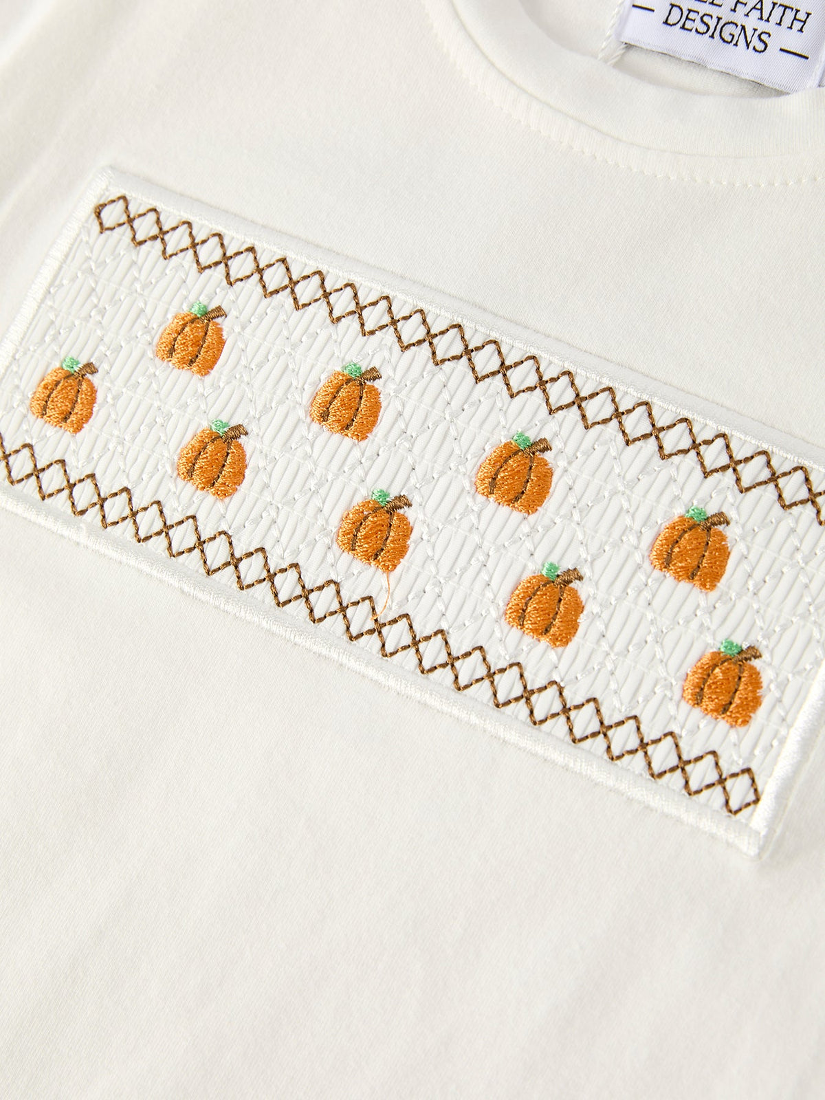 a white shirt with orange pumpkins on it