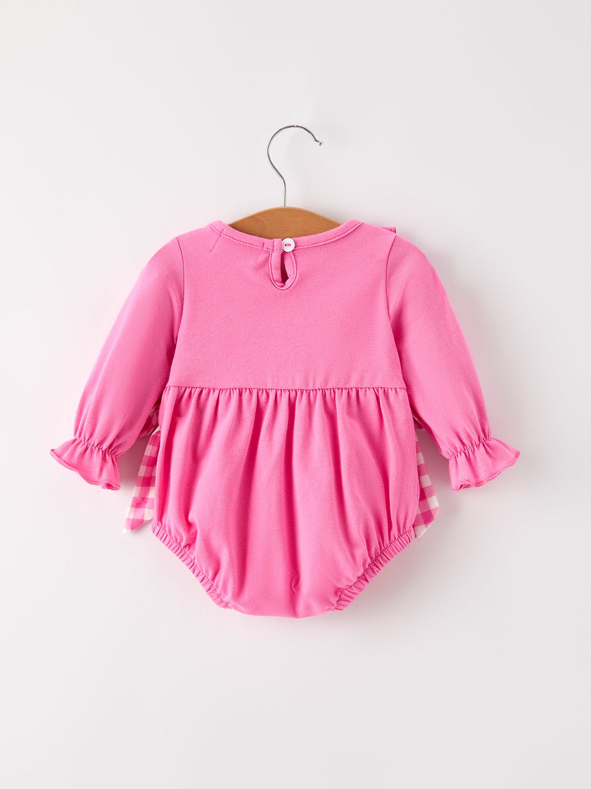 a pink baby romper on a swinger