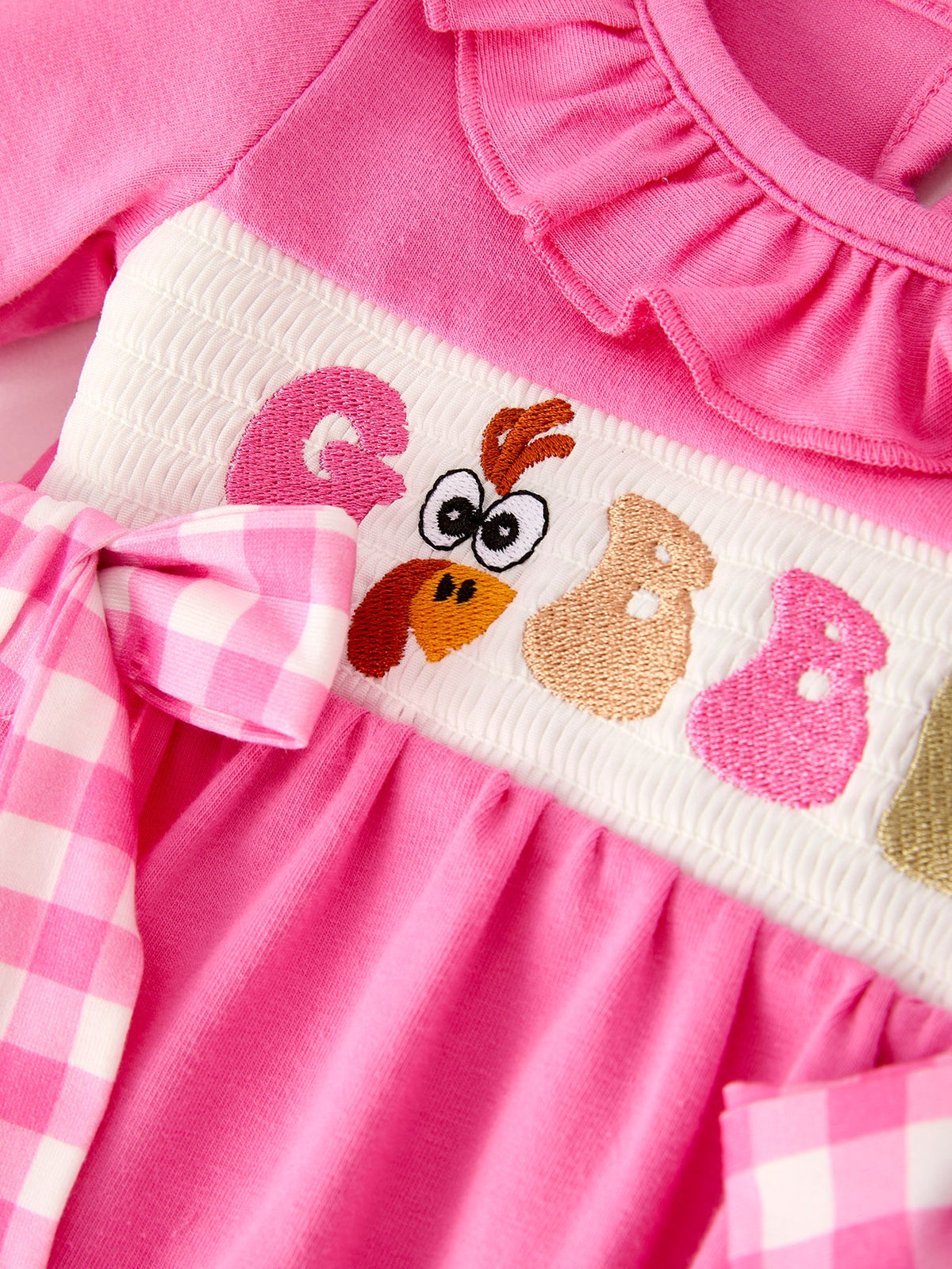 a pink dress with a bird embroidery