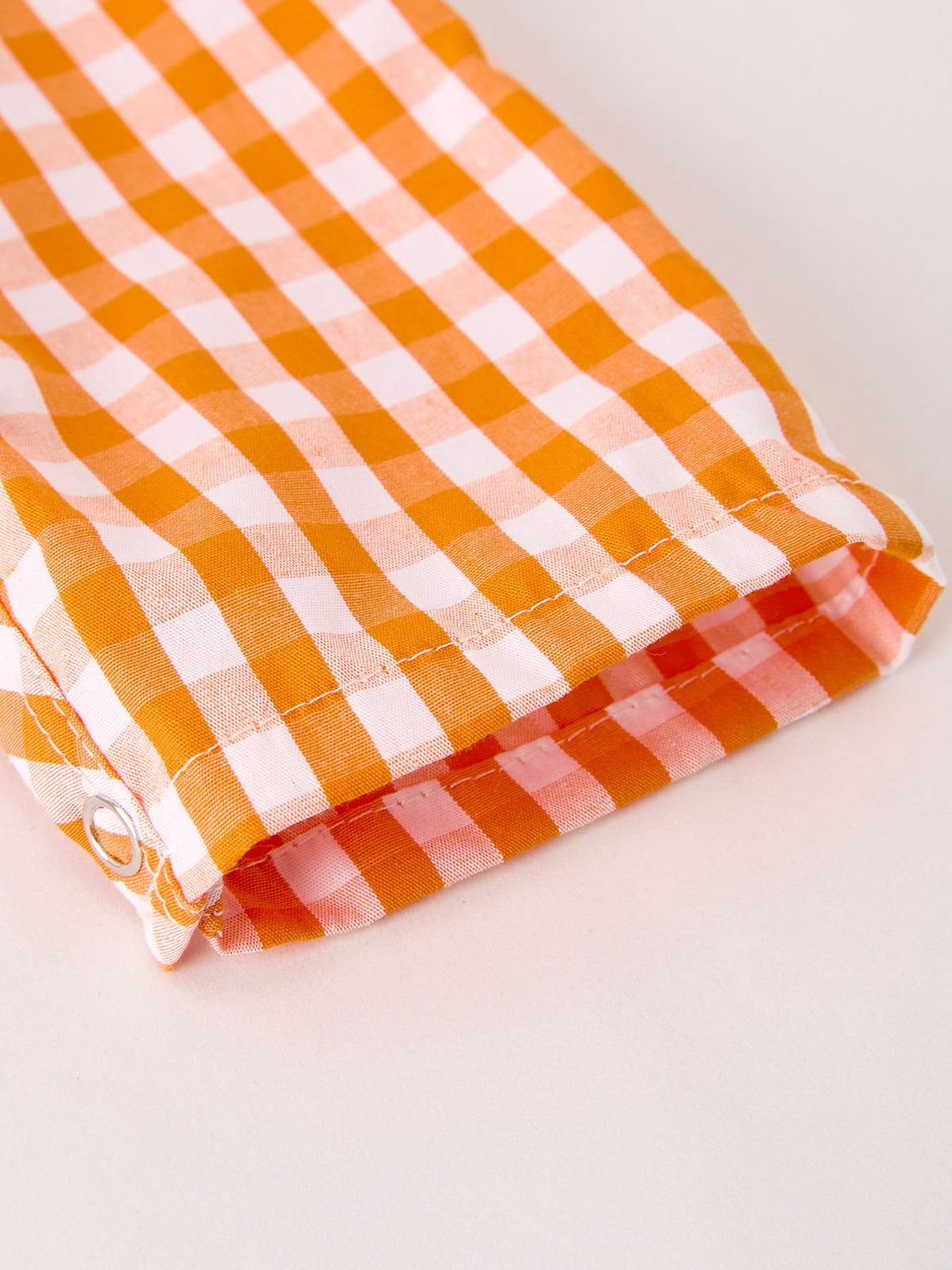 a close up of an orange and white checked shirt