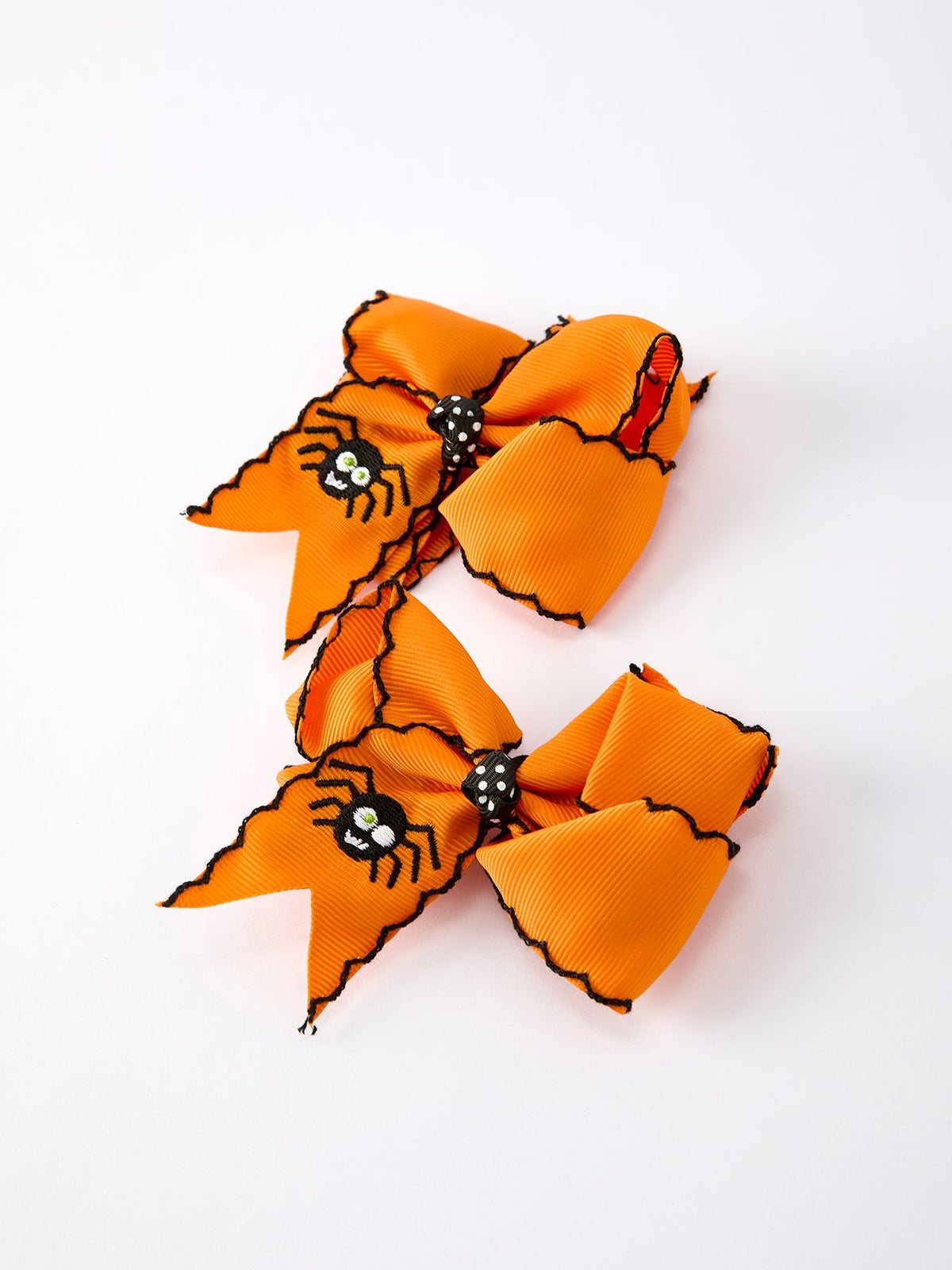a pair of orange bows with spiders