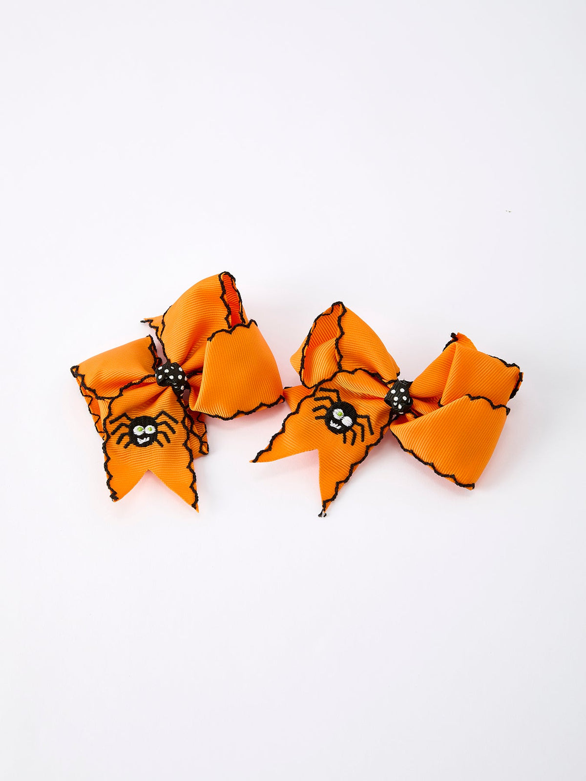 a pair of orange bows with spiders