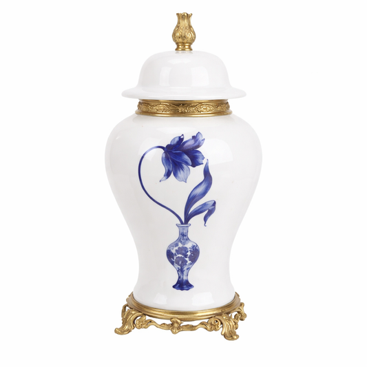 a white and blue vase with a gold base