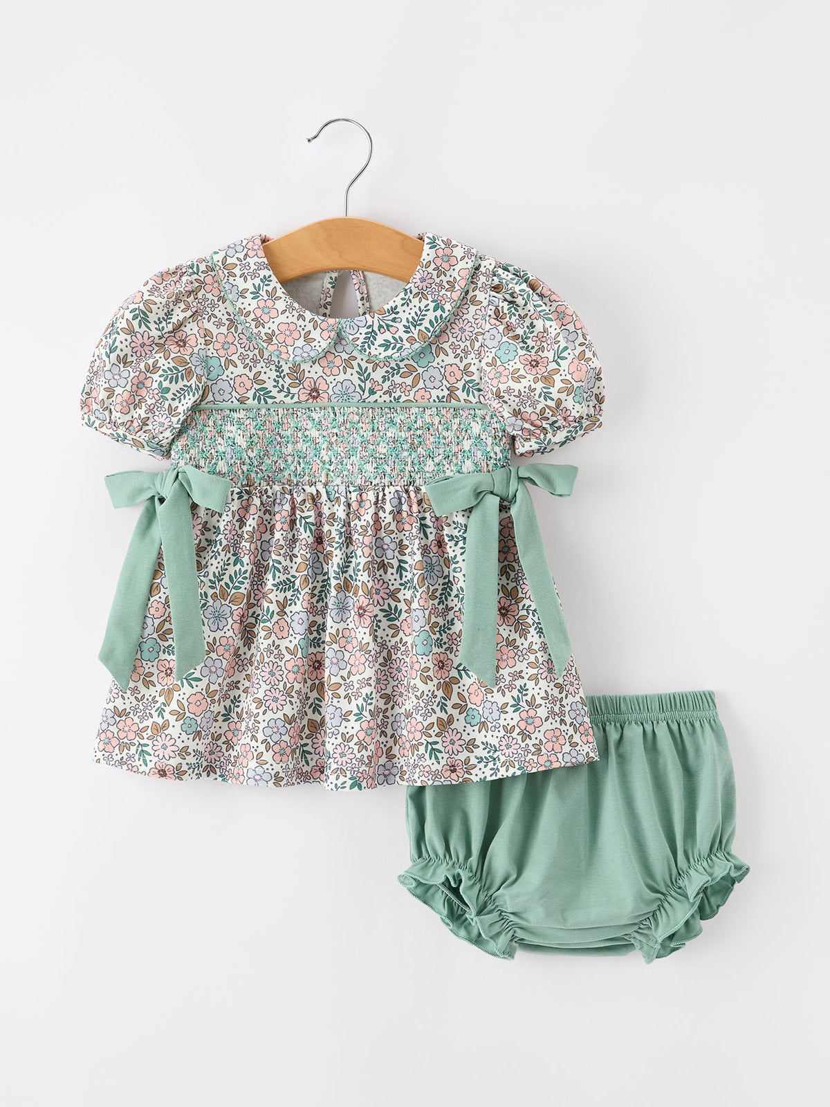 a baby dress and diaper on a swinger