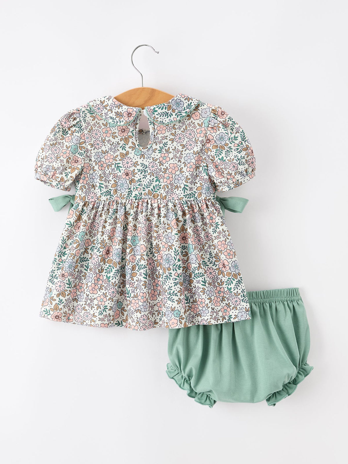 a baby dress and diaper on a swinger