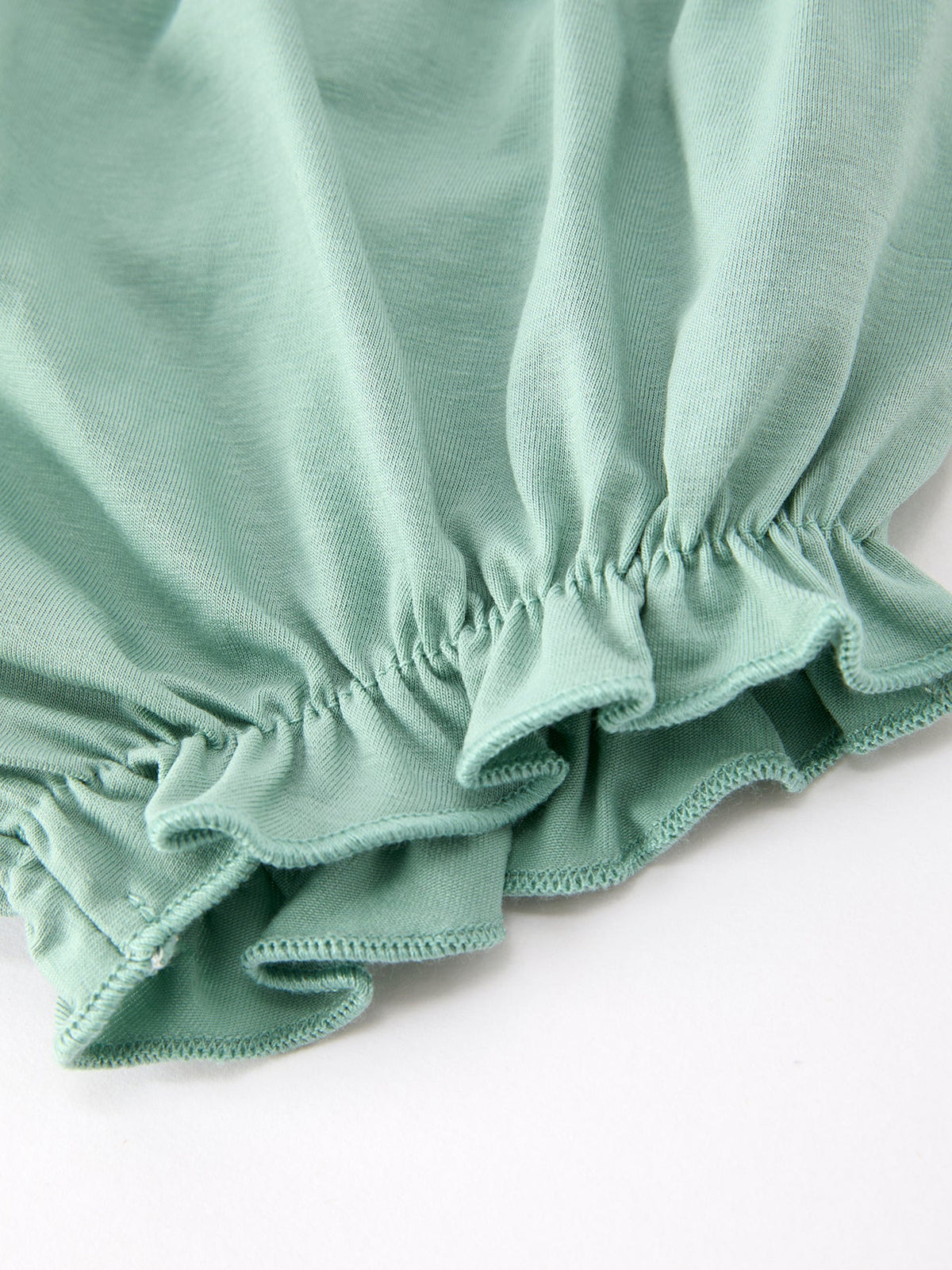 a green fabric with ruffles