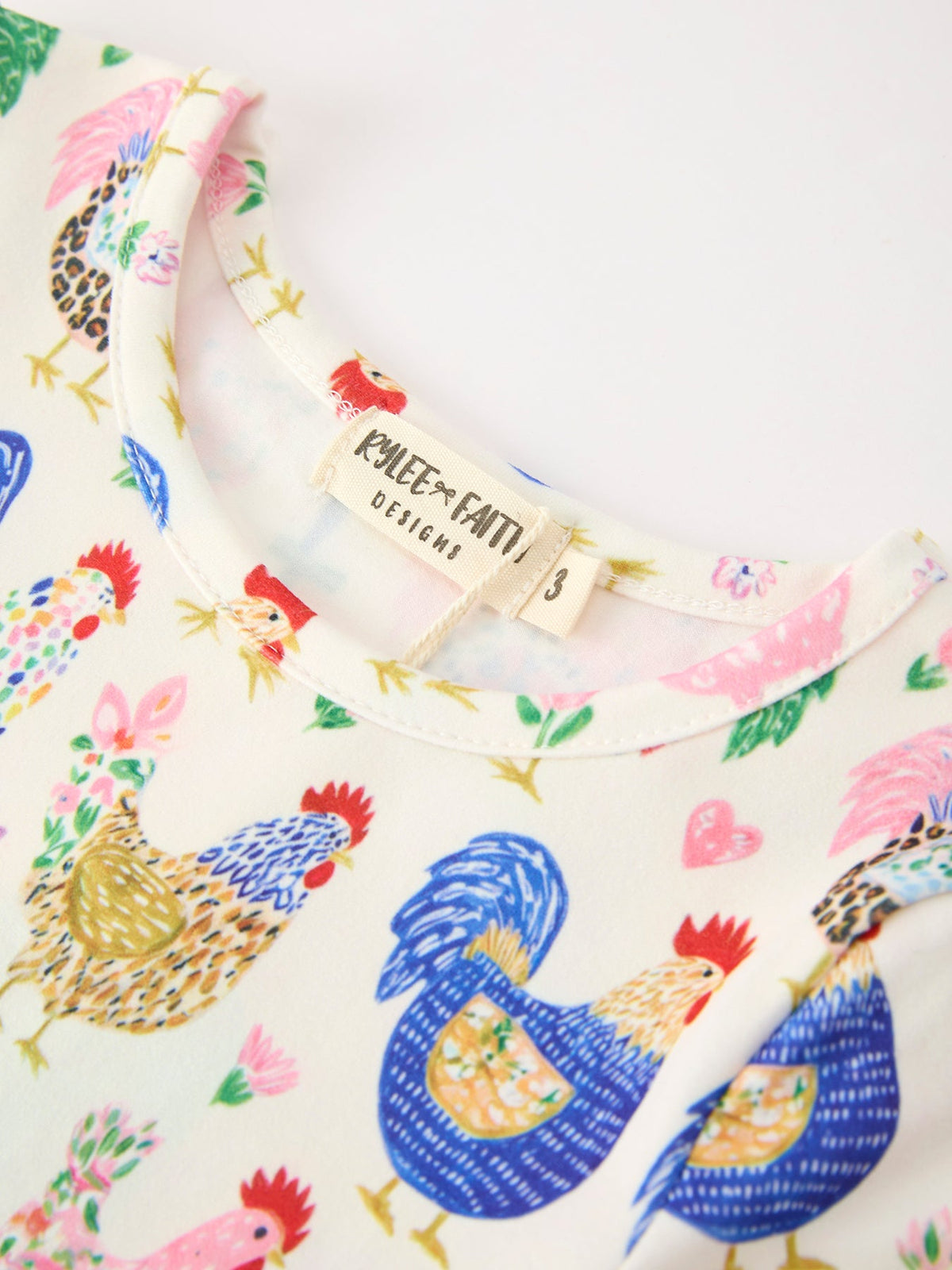 a white shirt with roosters and flowers