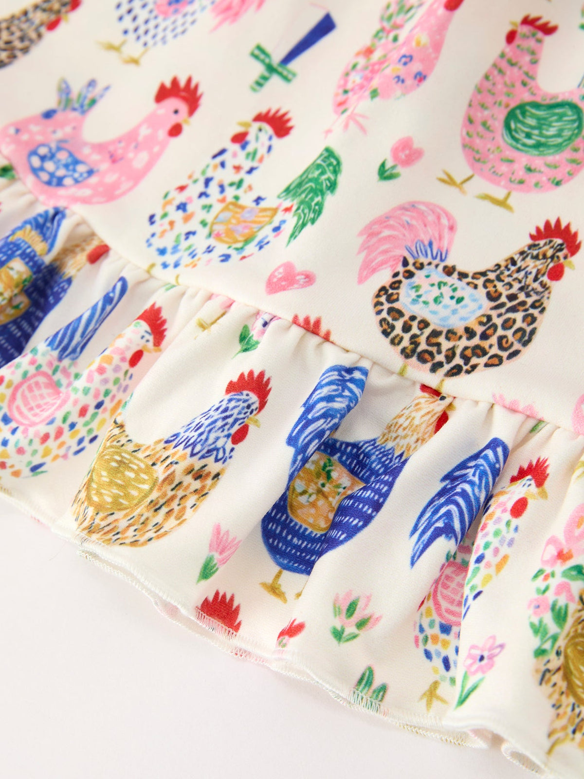 a white fabric with colorful roosters and pineapples