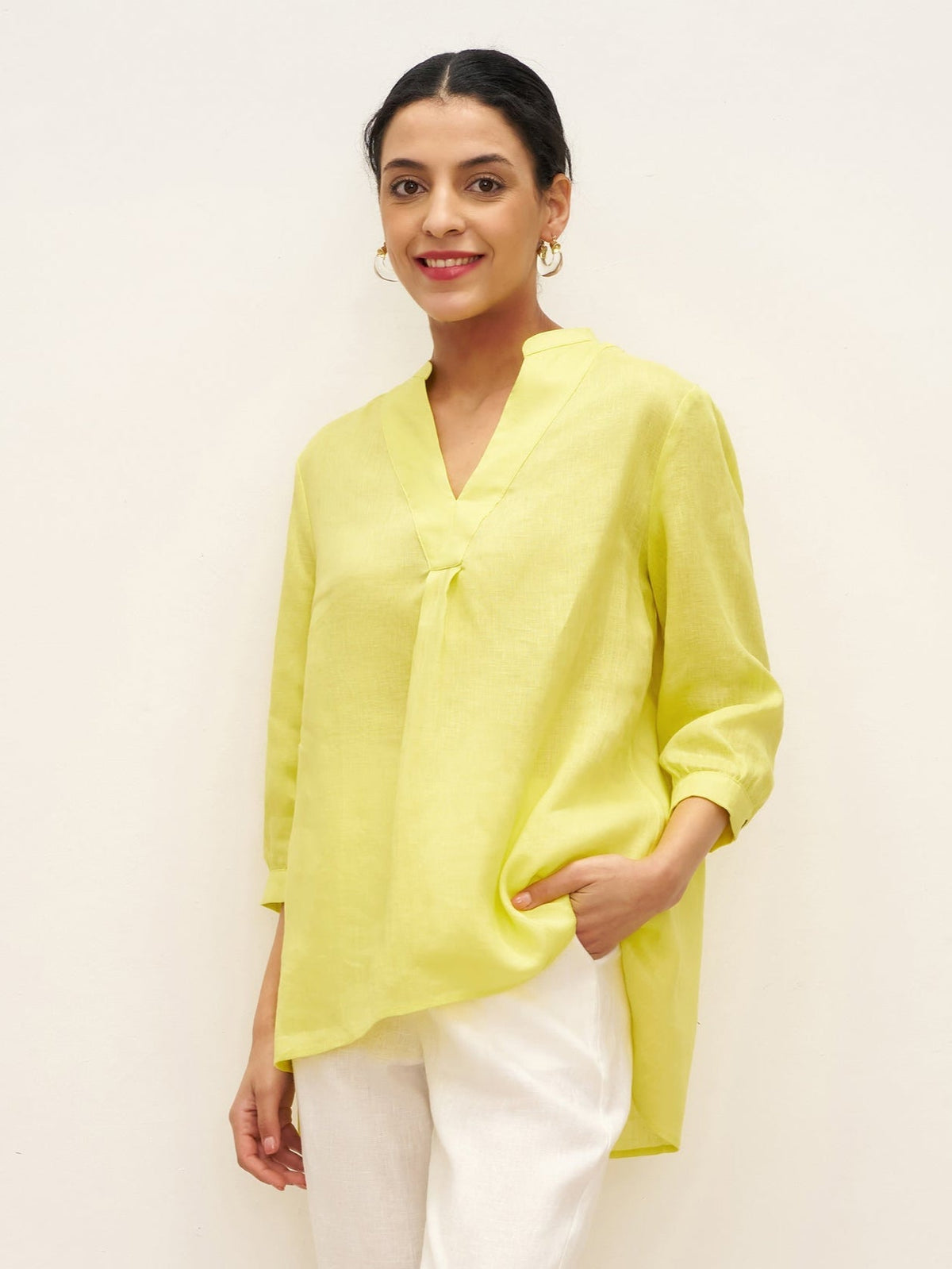a woman in yellow shirt and white pants