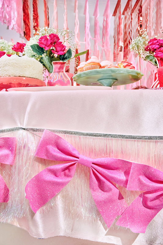 a table with pink bows and flowers
