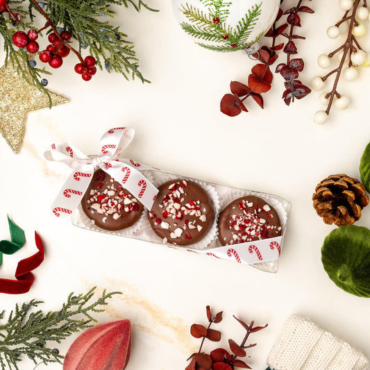 a box of chocolate candies with candy cane sprinkles and decorations