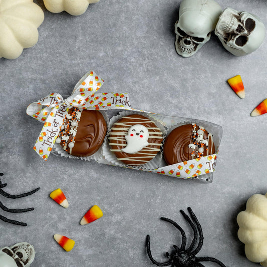 a box of cookies with white and brown frosting and a bow