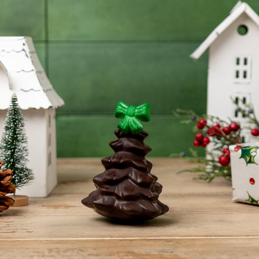 a chocolate christmas tree with a green bow and pine cones