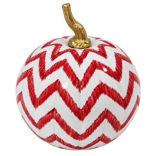 a white and red pumpkin with a gold stem