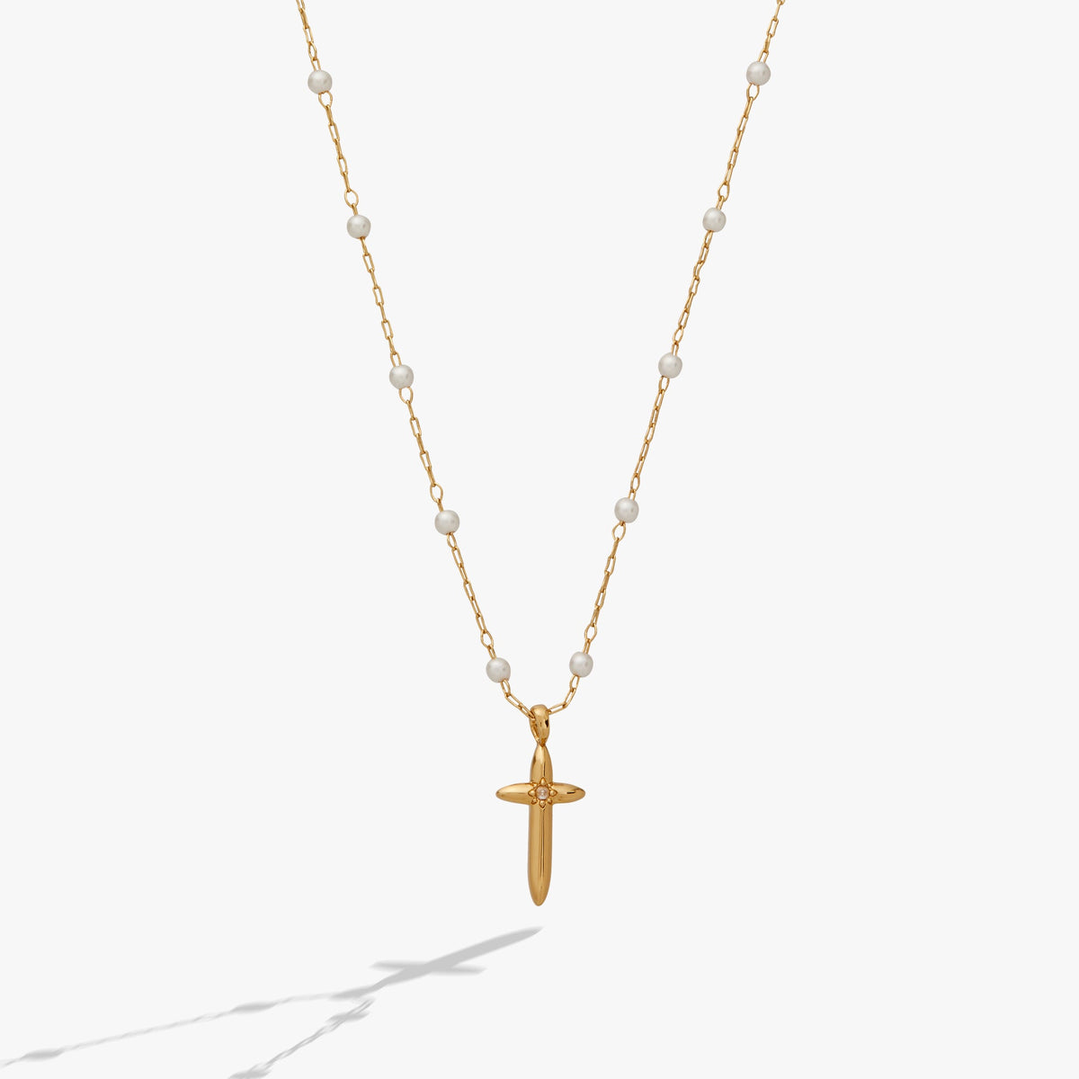 a gold necklace with a cross pendant