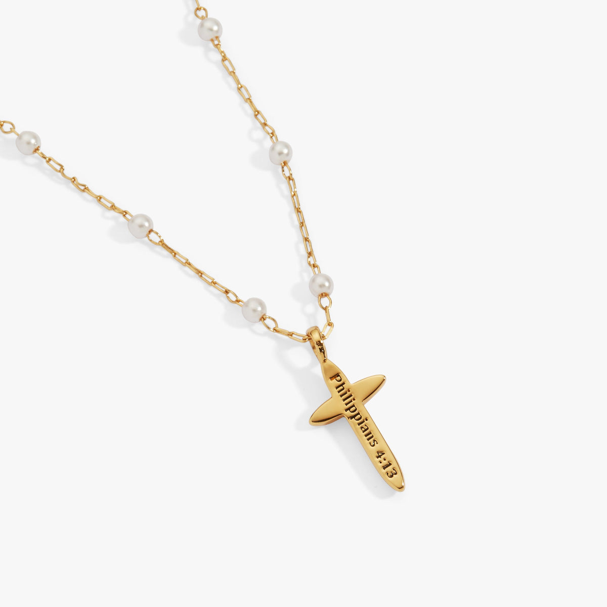 a gold necklace with a cross and pearls
