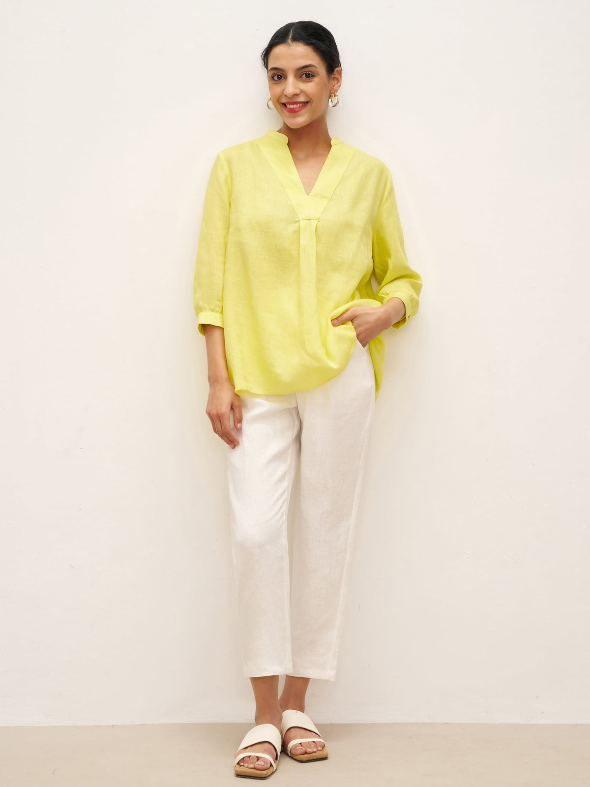 a woman in yellow shirt and white pants