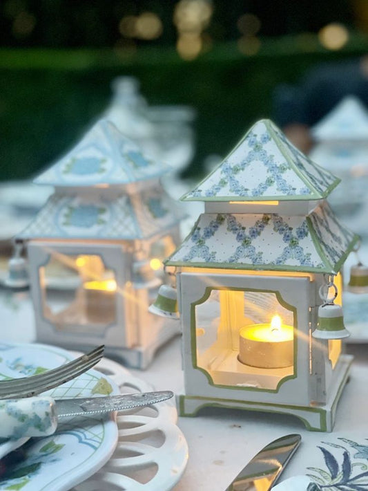 a small white and blue lanterns with a lit candle