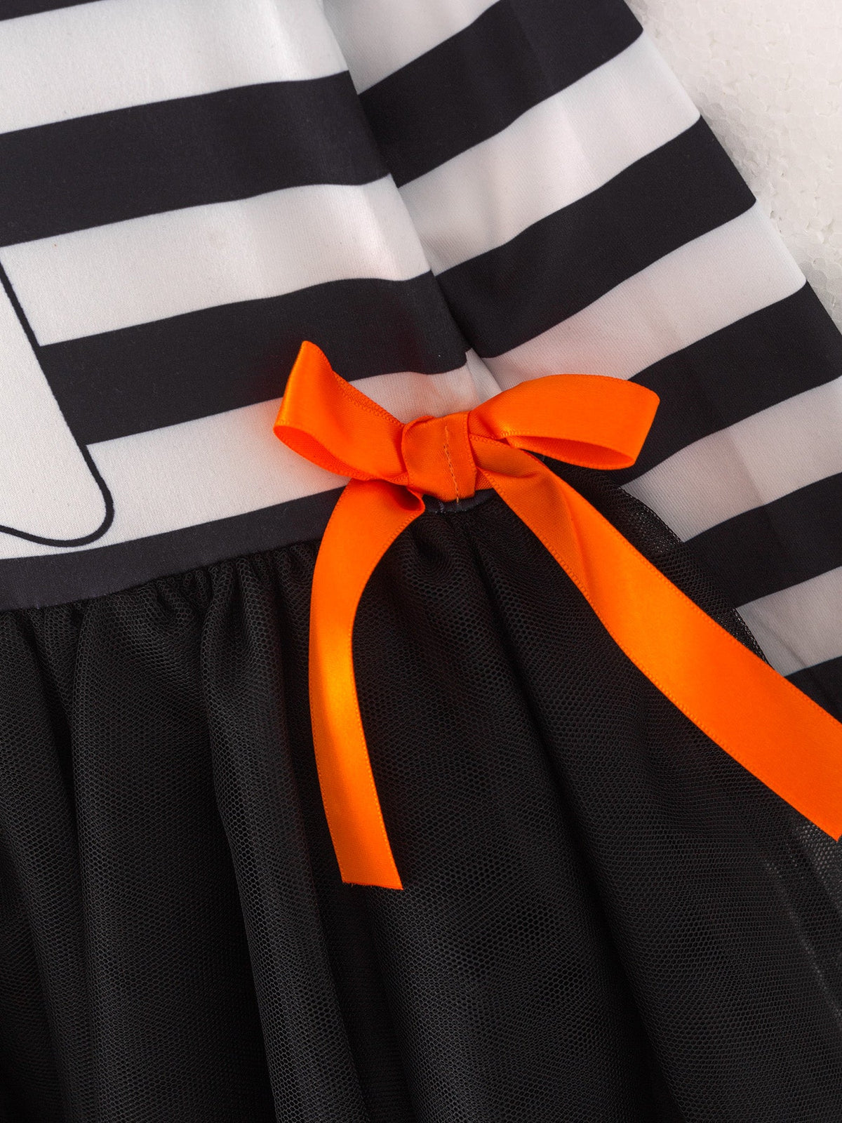 a black and white striped dress with orange bow