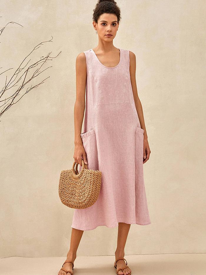 a woman in a pink dress holding a straw bag