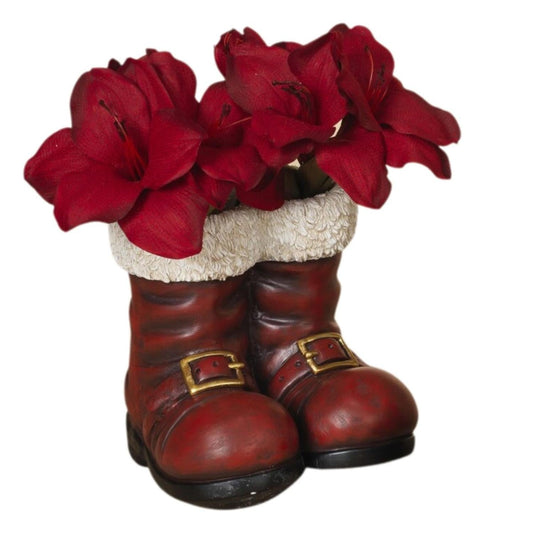a red flower vase with red flowers in boots