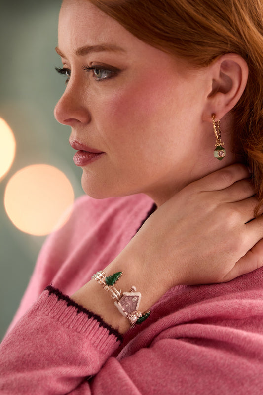 a woman wearing a pink sweater and earrings