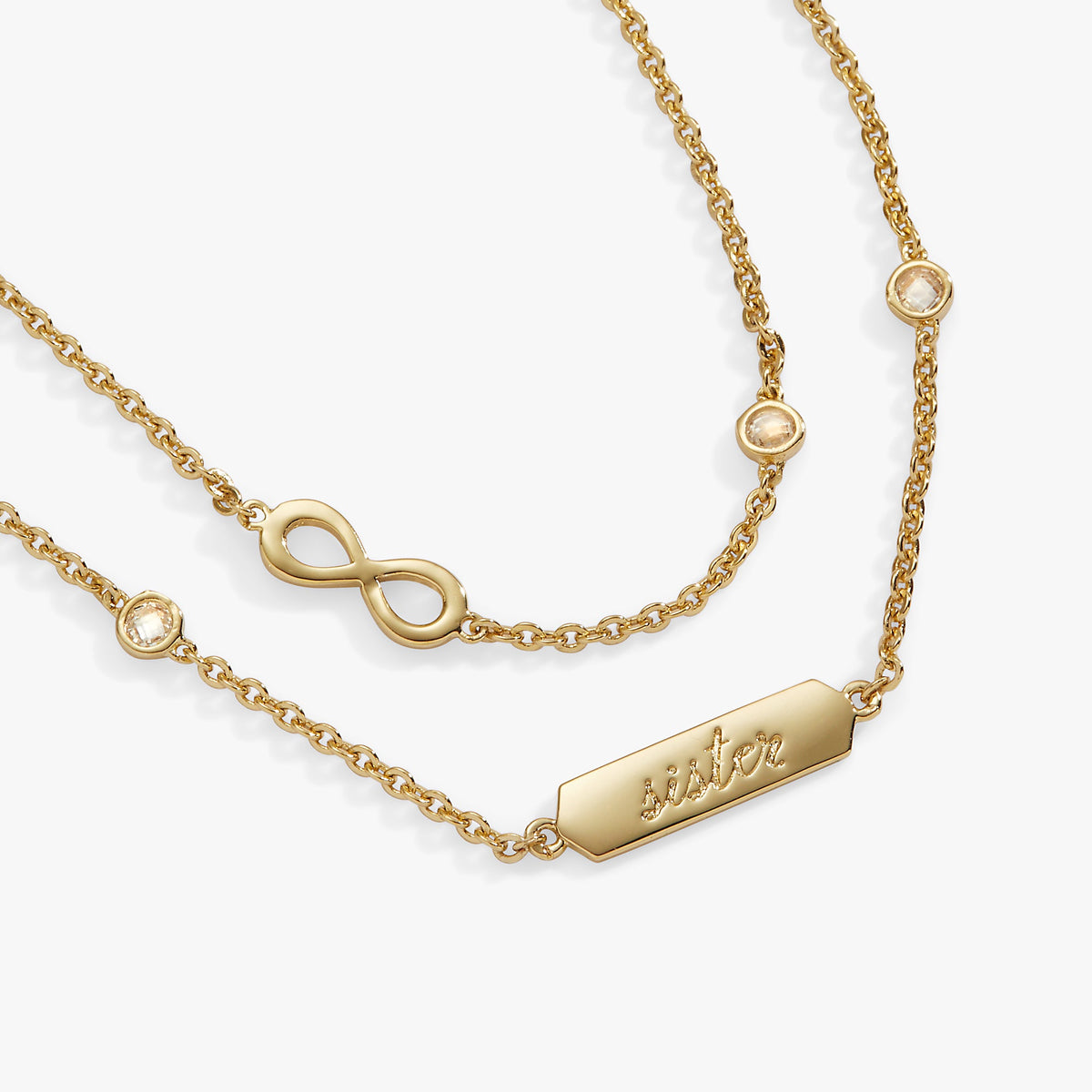 a gold chain with a name tag and a infinity symbol