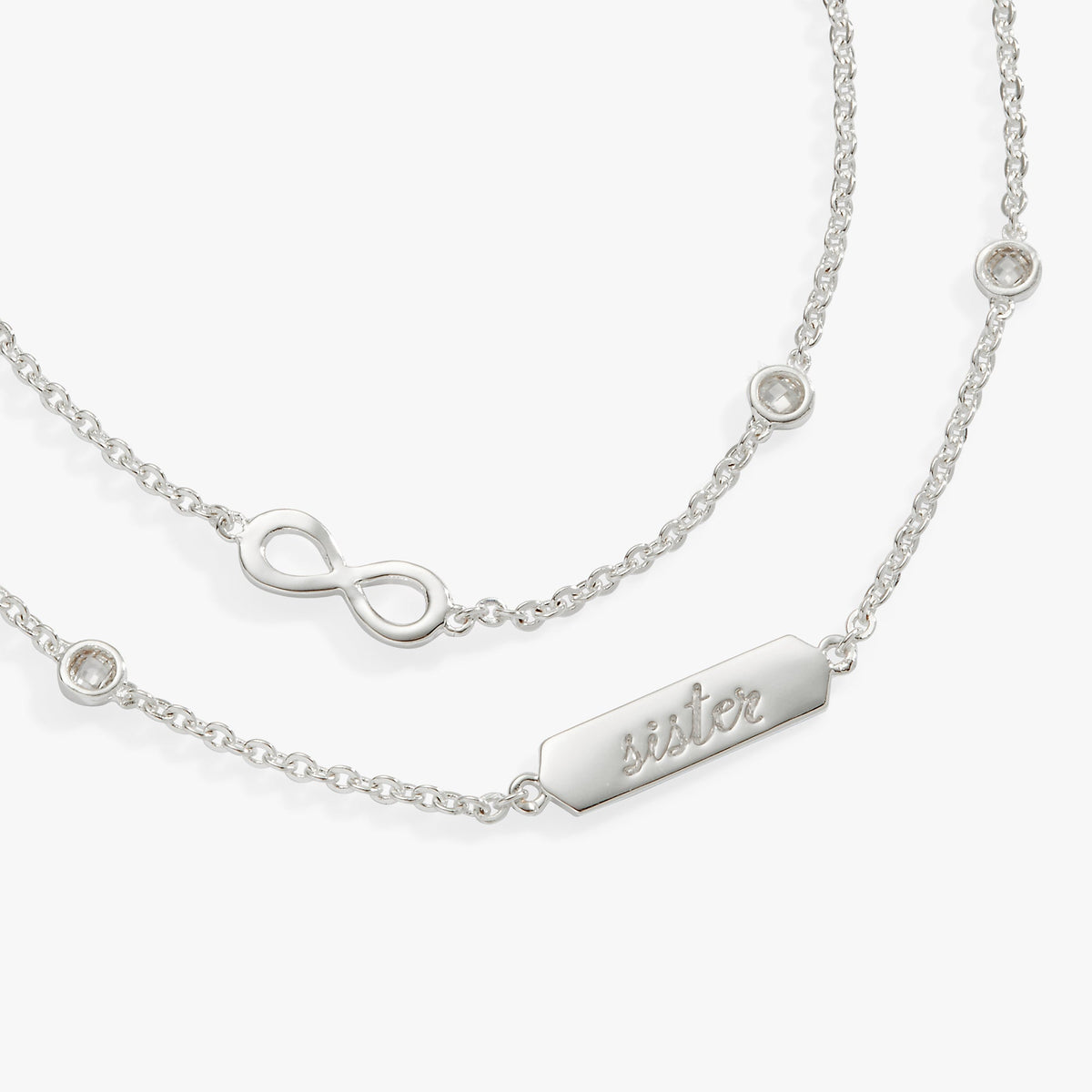 a silver necklace with a name and a diamond