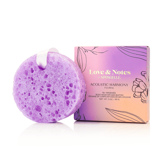 a purple sponge with a white ribbon next to a box