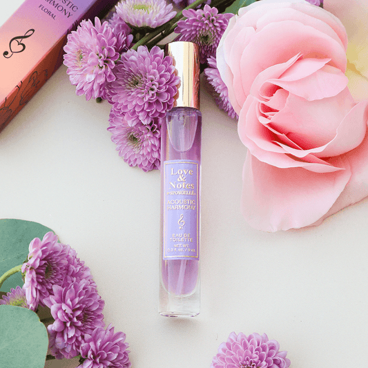 a bottle of perfume next to flowers