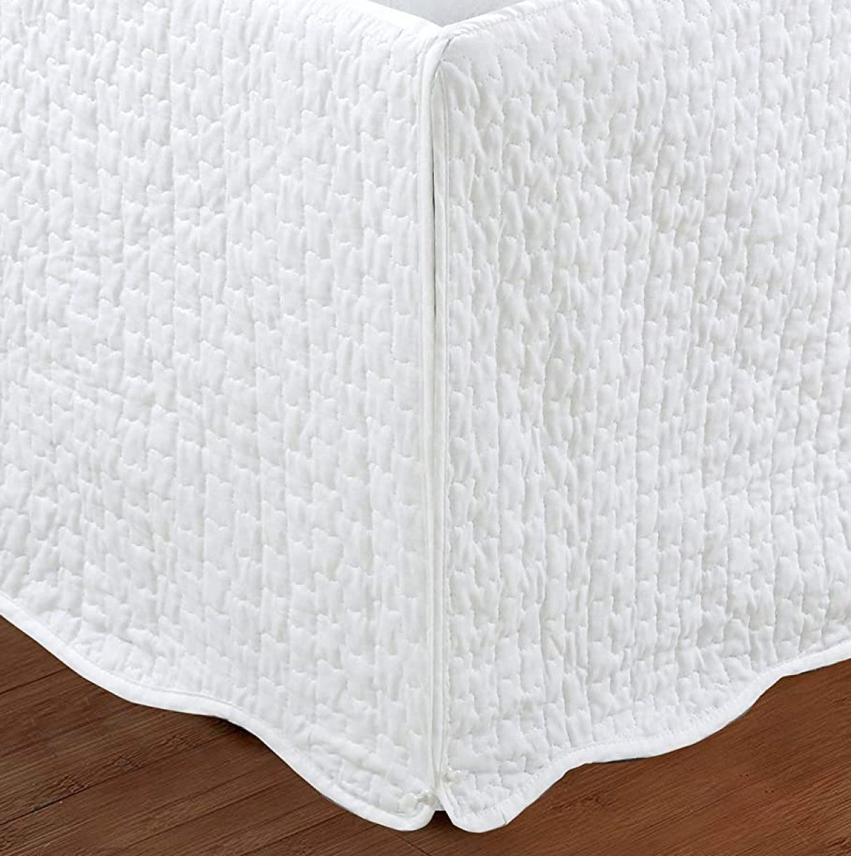 a white bed frame with a quilted edge