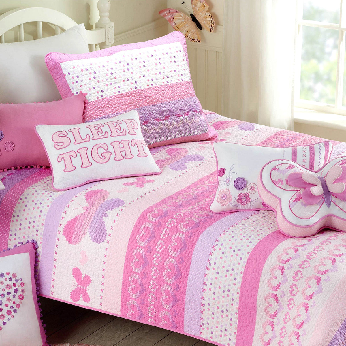 a bed with pillows and butterflies