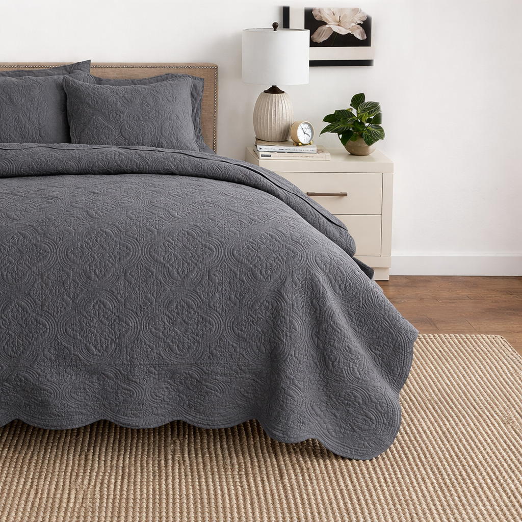 a bed with a grey blanket and pillows