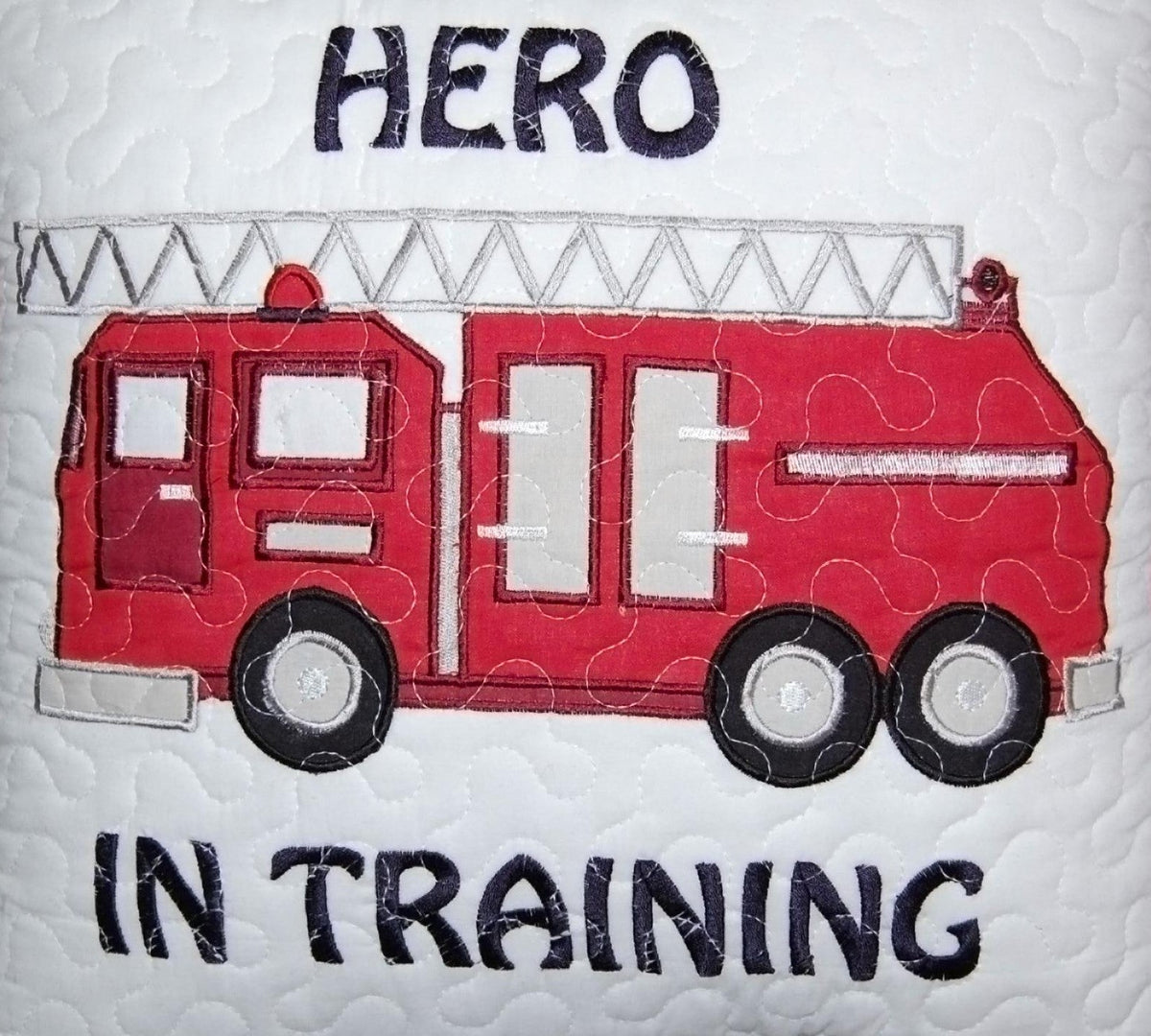 a red fire truck on a white quilt