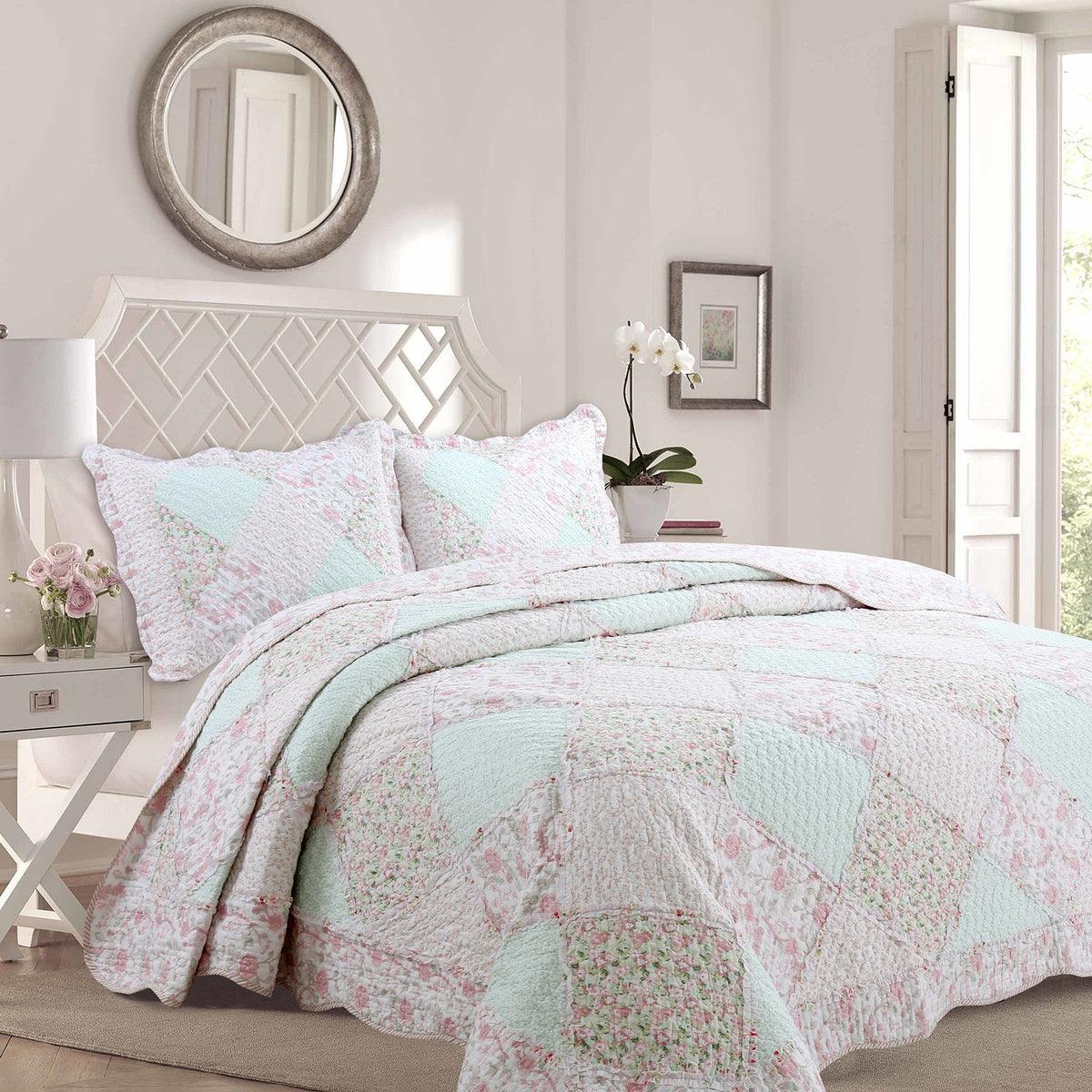 a bed with a pink and white quilt