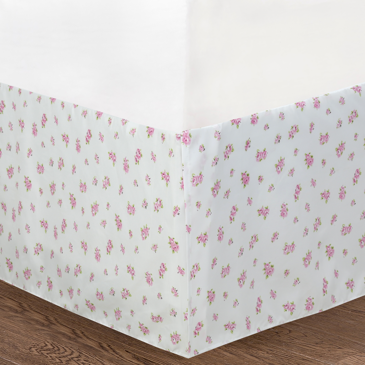 a white bed skirt with pink flowers on it