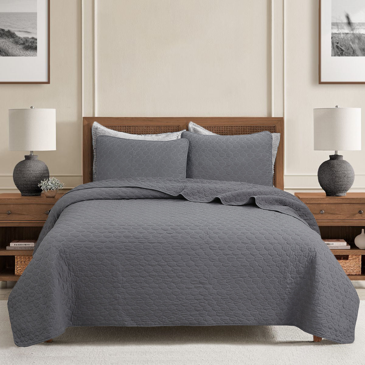 a bed with a grey blanket and two lamps