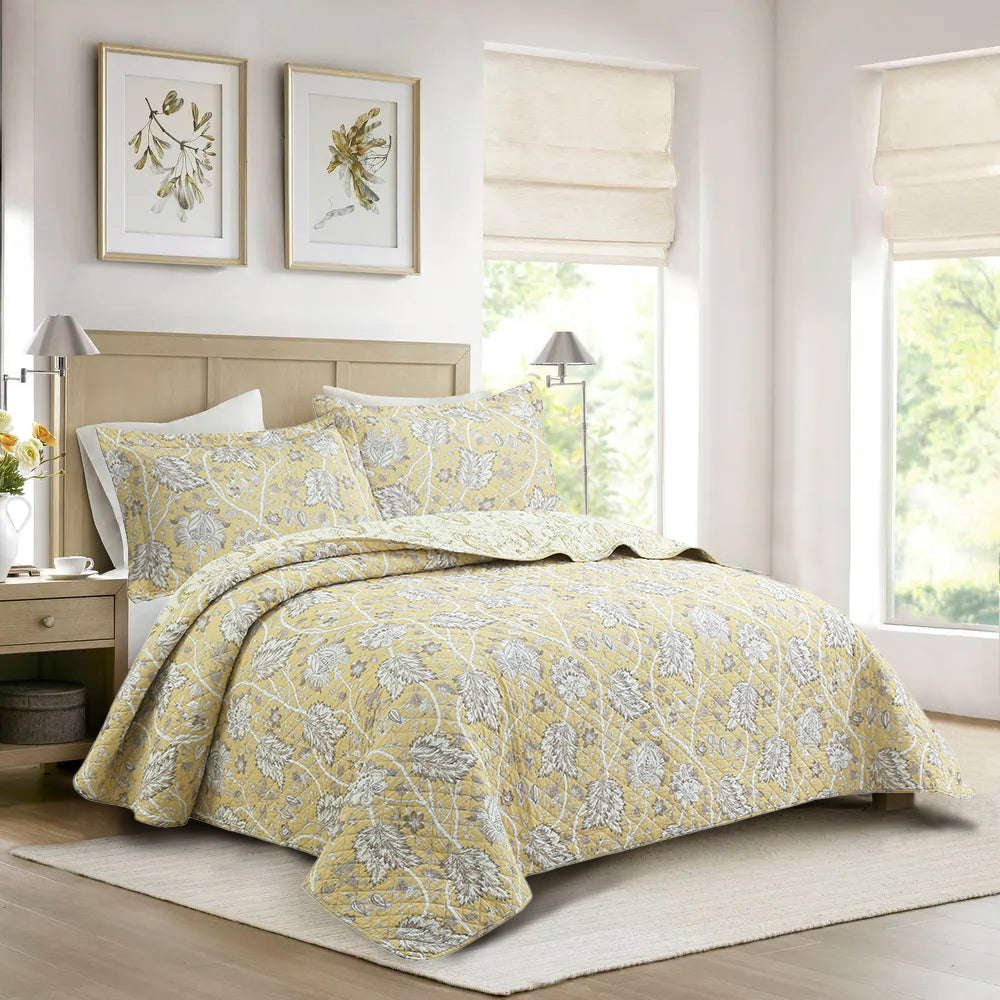 a bed with a yellow comforter and pillows