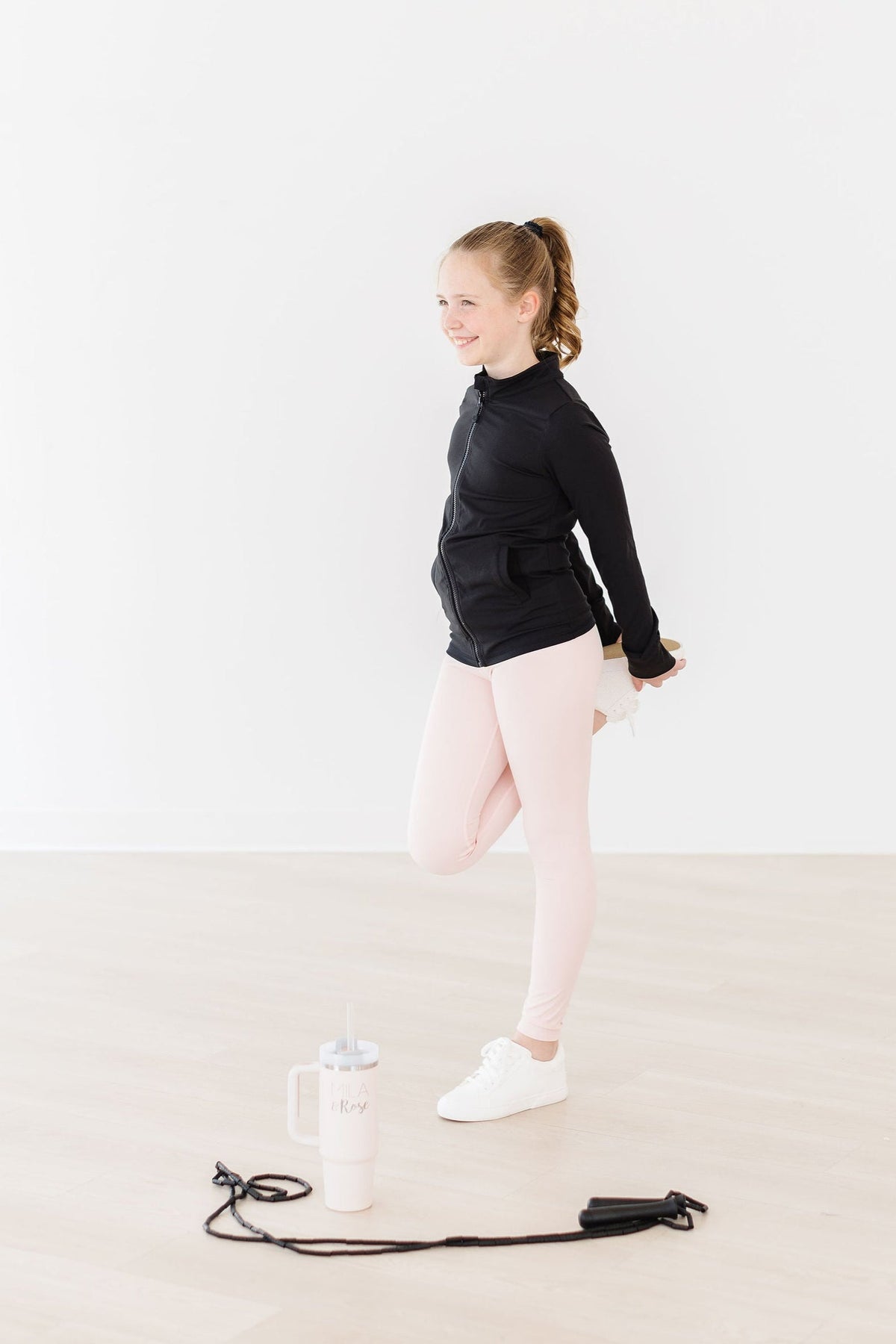 a girl in black shirt and pink leggings