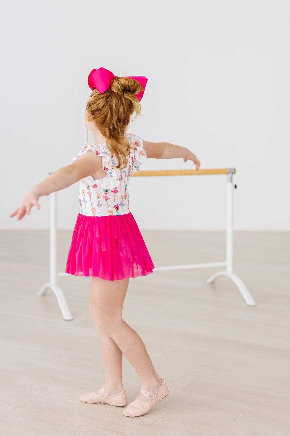 a girl in a pink skirt and a bow