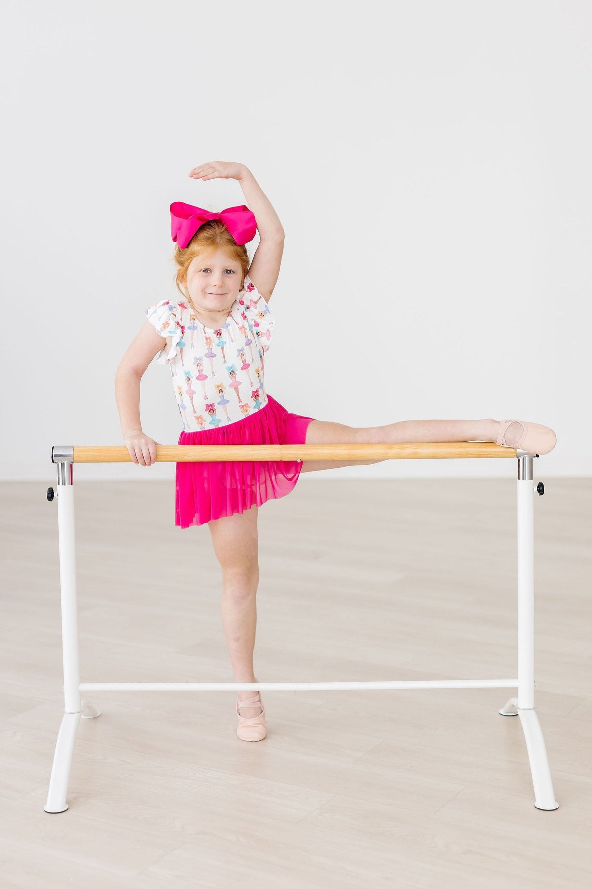 a girl in a pink skirt and a bow on her head