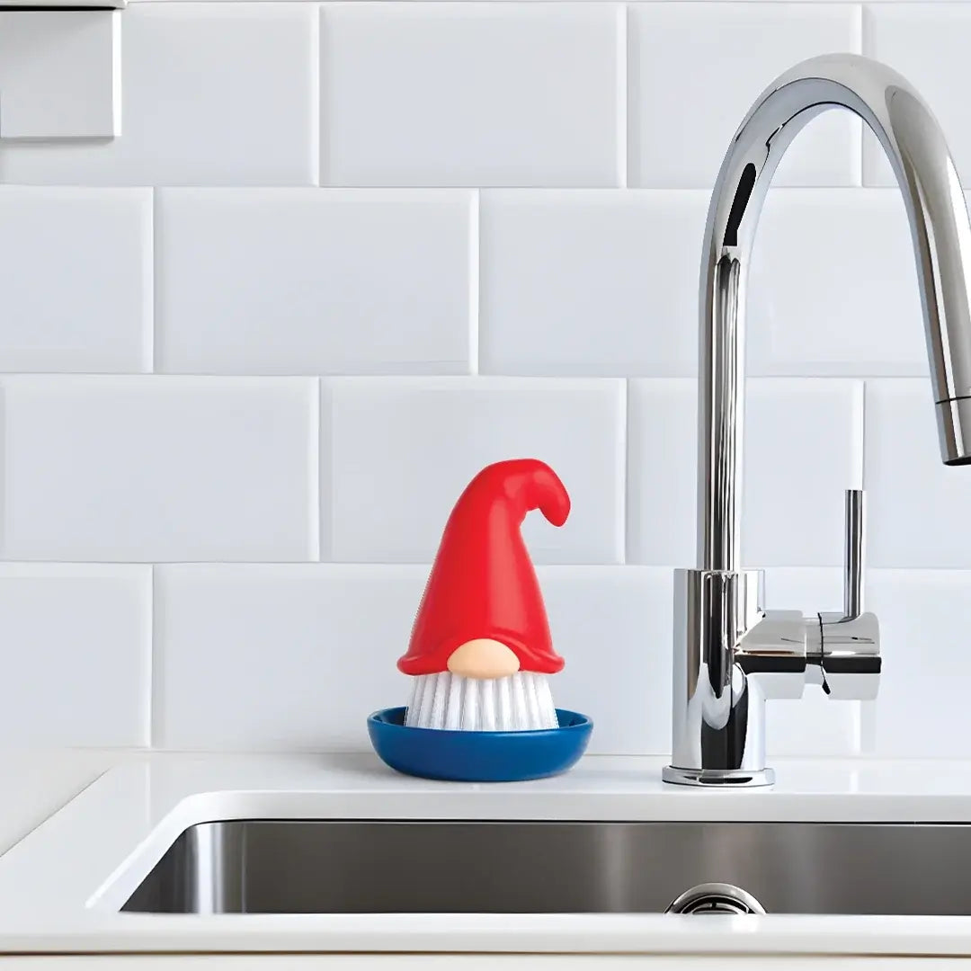 a dish brush and a red hat on a white countertop