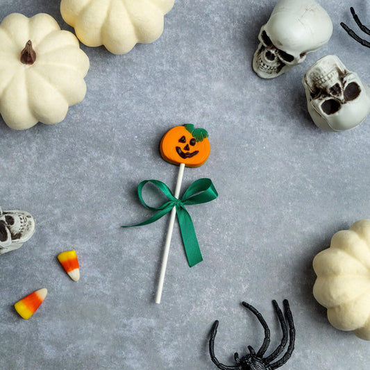 a lollipop with a bow and a bow surrounded by white pumpkins