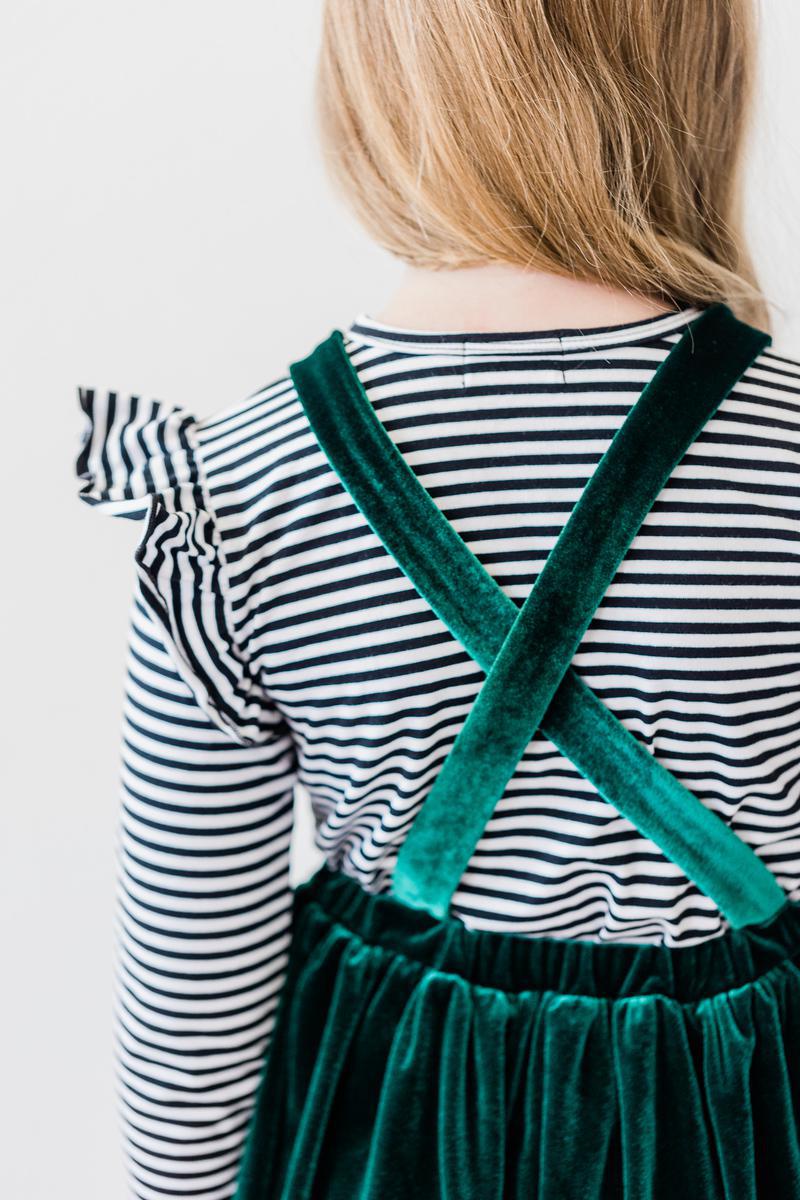 a girl wearing a striped shirt and green dress