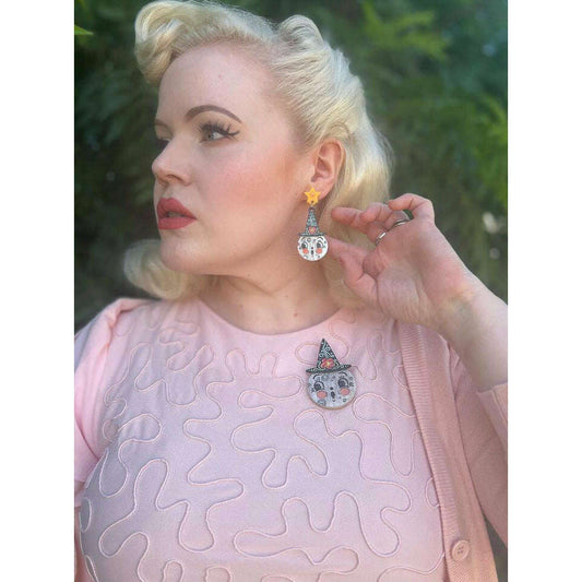 a woman wearing a pink sweater and earrings