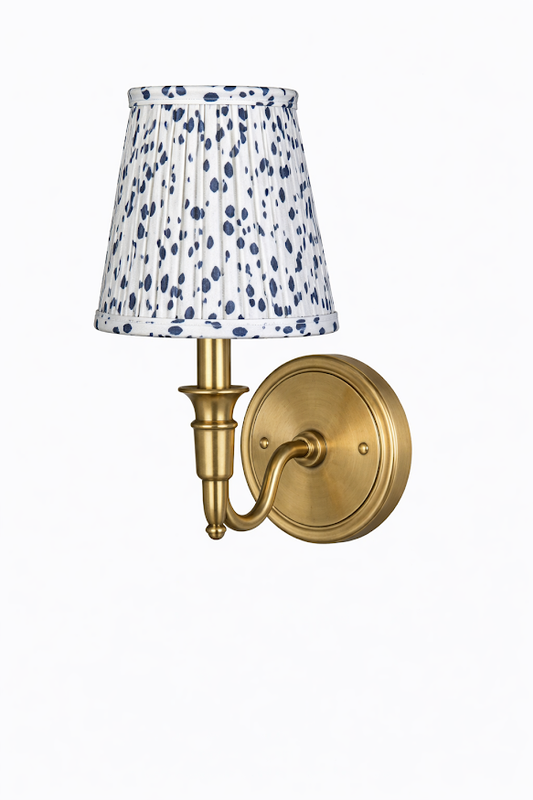 a gold wall lamp with a white and blue shade