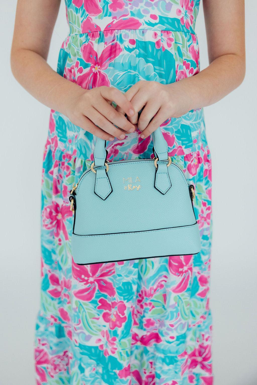 a person holding a blue purse
