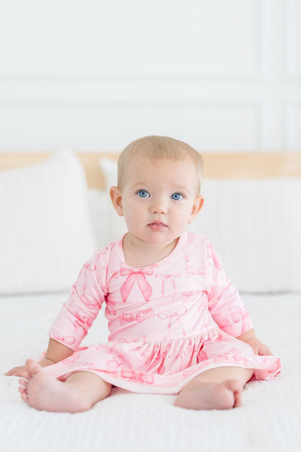 a baby sitting on a bed