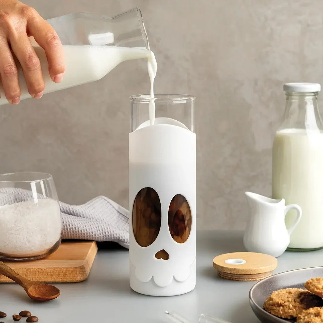 a person pouring milk into a glass
